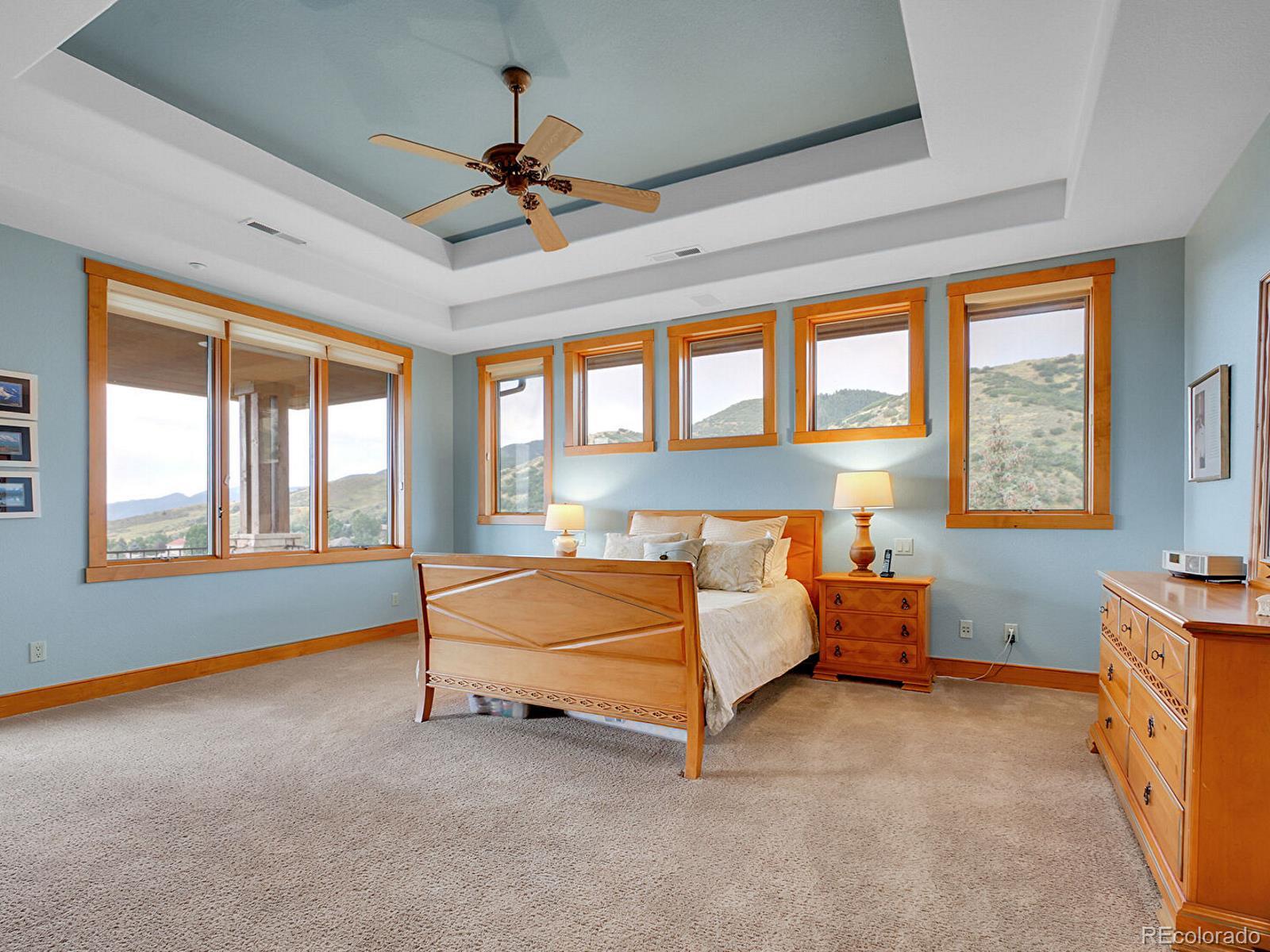 16285 Sandstone Drive Morrison, CO 80465 - Photo 20 of 47 a bed room with a bed and a ceiling fan
