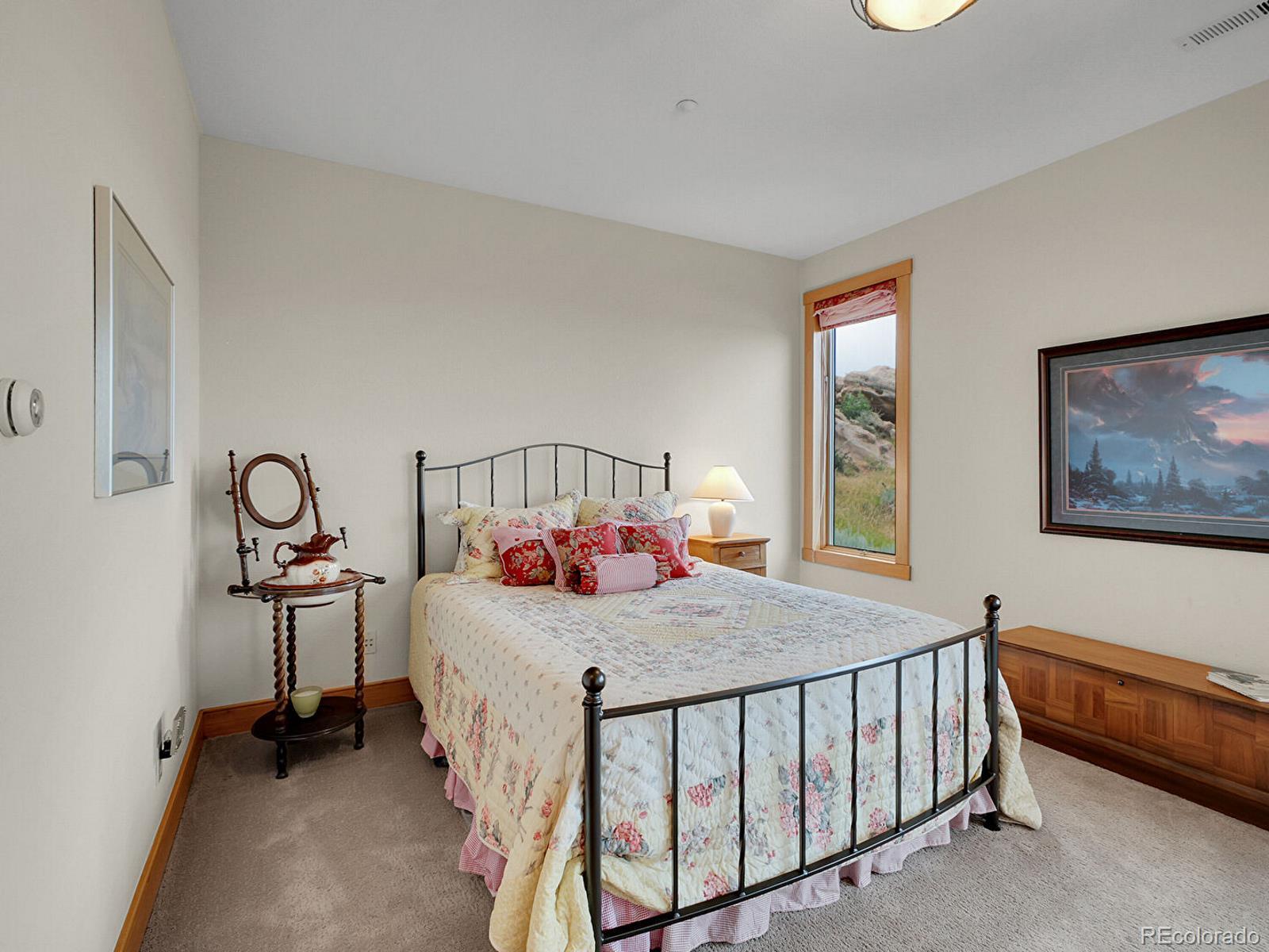 16285 Sandstone Drive Morrison, CO 80465 - Photo 26 of 47 a bedroom with a bed and a table