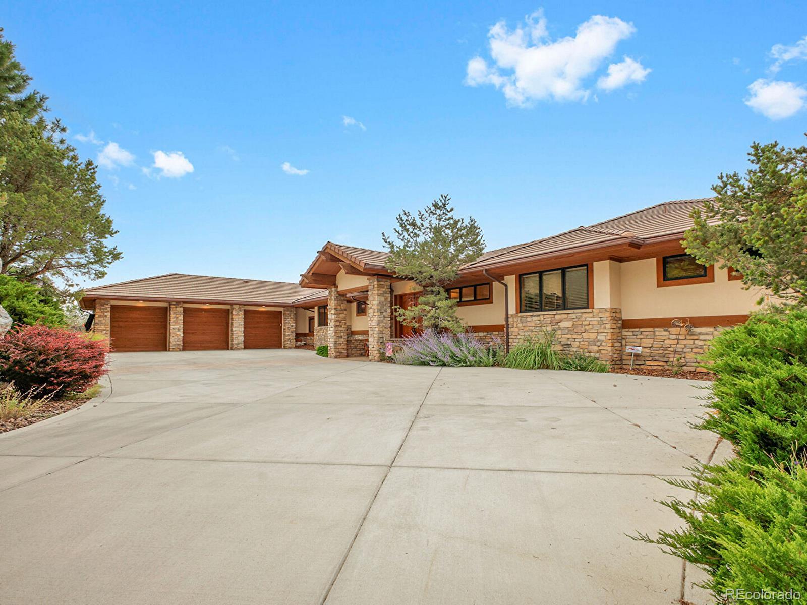 16285 Sandstone Drive Morrison, CO 80465 - Photo 3 of 47 a front view of a house with a yard and garage