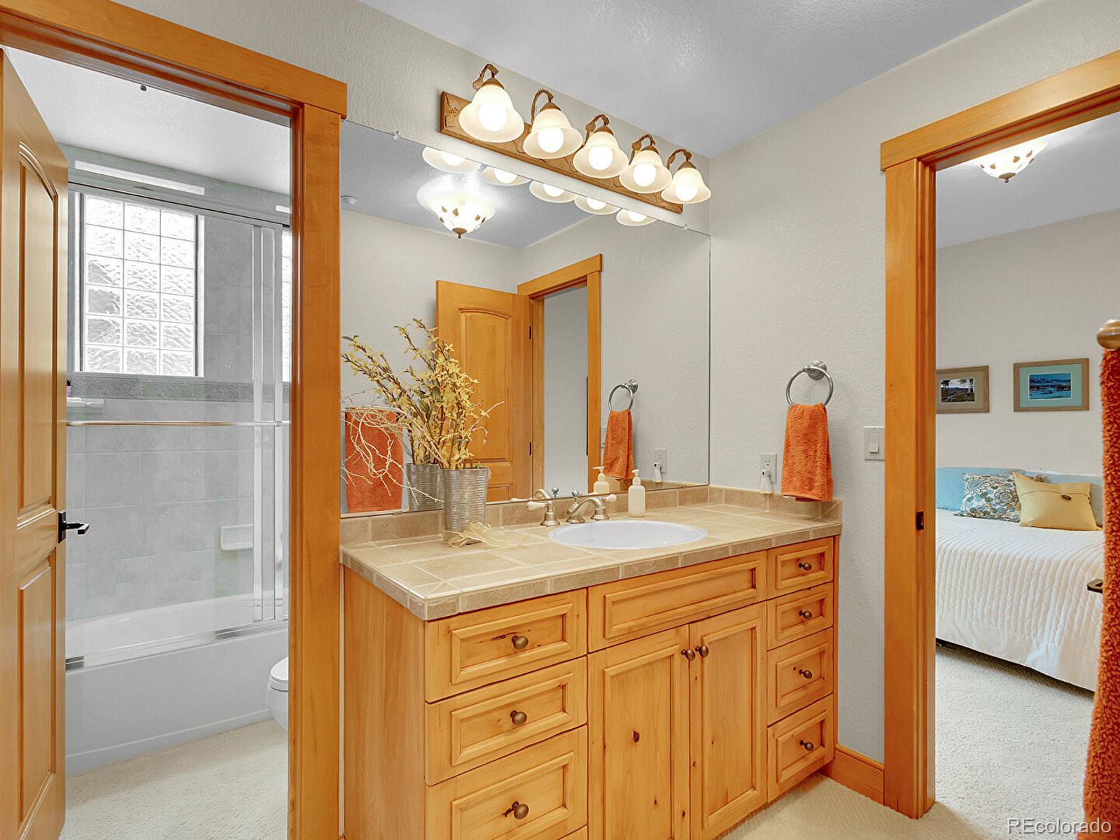 16285 Sandstone Drive Morrison, CO 80465 - Photo 35 of 47 a bathroom with a sink vanity tub and a mirror