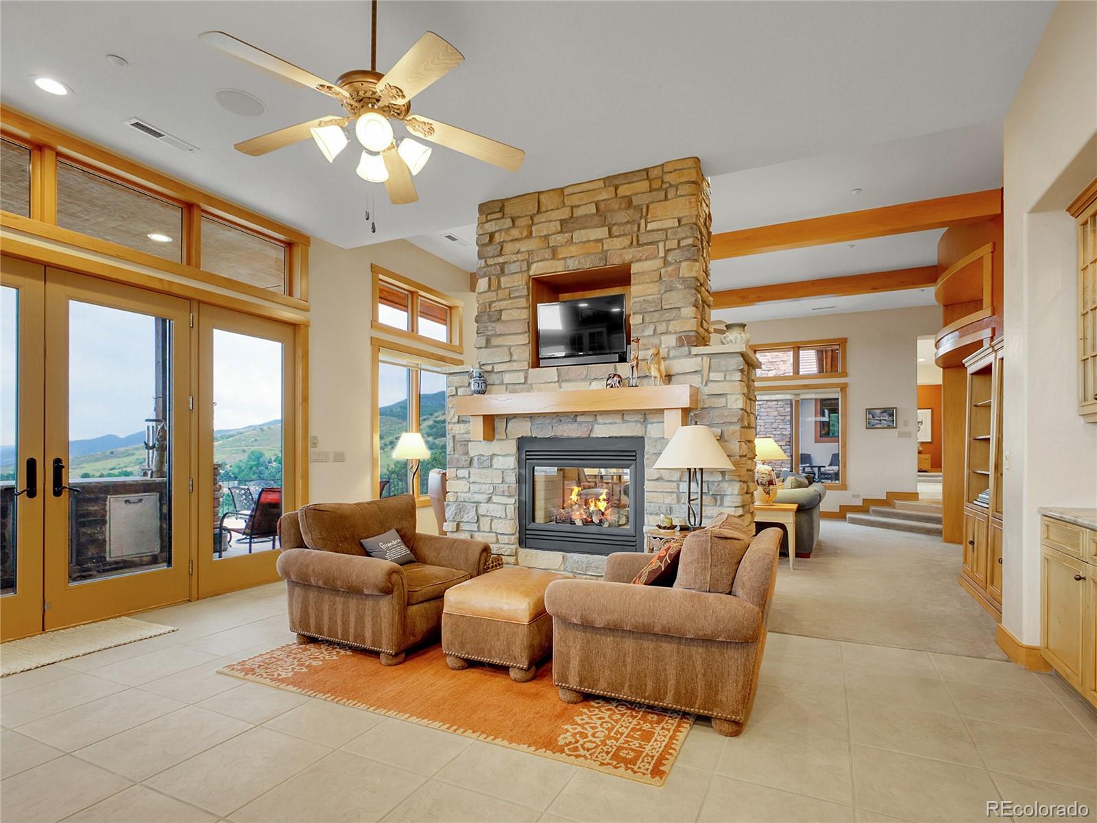 16285 Sandstone Drive Morrison, CO 80465 - Photo 9 of 47 a living room with furniture a fireplace and a flat screen tv