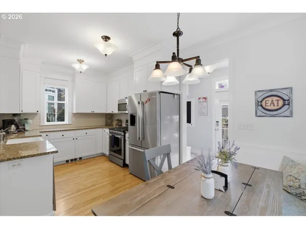 a kitchen with stainless steel appliances kitchen island granite countertop a refrigerator a stove and a sink