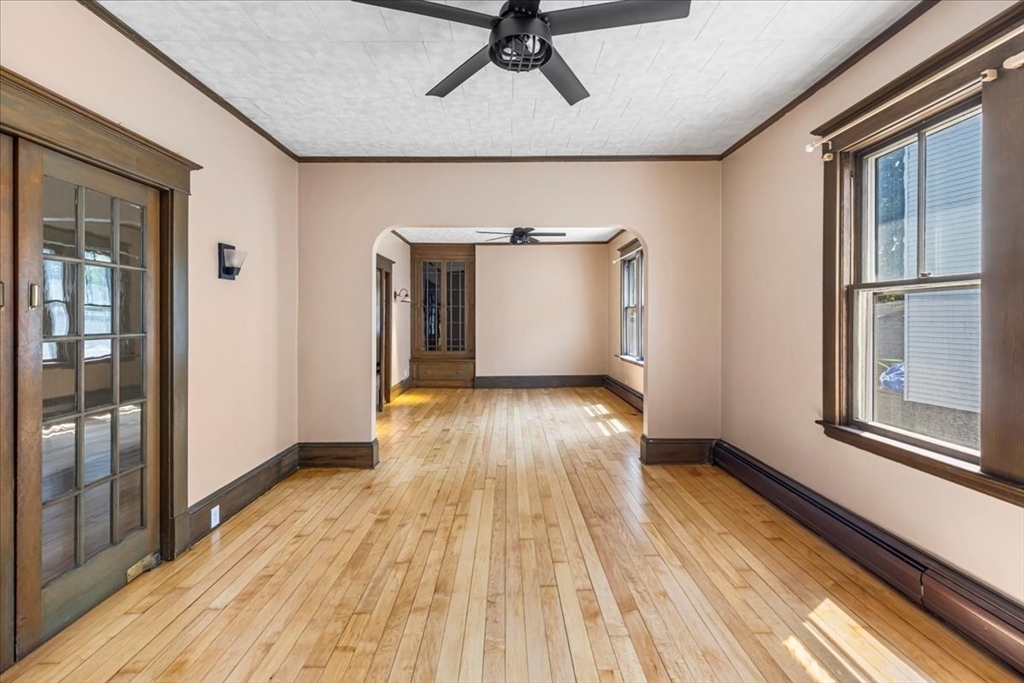 313 Main Street Fairhaven, MA 02719 - Photo 11 of 42 a view of a room with wooden floor a ceiling fan and windows