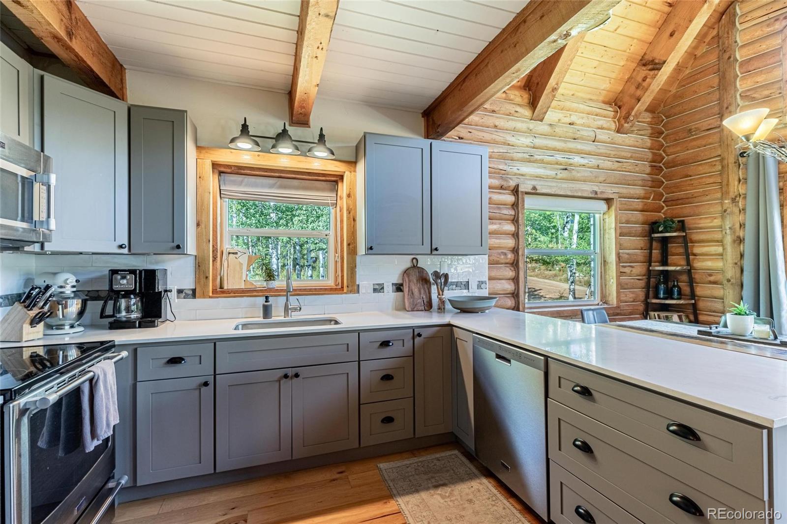58165 Jupiter Place Clark, CO 80428 - Photo 11 of 34 a kitchen with a sink stove cabinets and wooden floor
