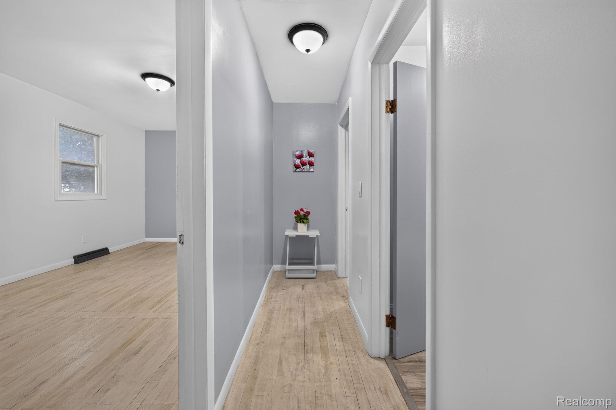 9288 Hilda Lane Flushing, MI 48433 - Photo 16 of 50 Hallway featuring light wood-finish flooring and a flush-mount ceiling light fixture