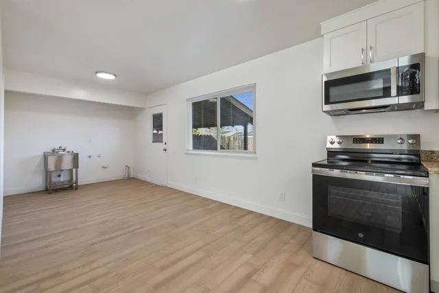 a kitchen with stainless steel appliances a stove a microwave and sink