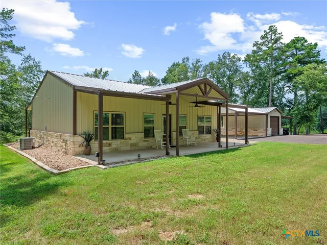 a view of a house with a yard and sitting area