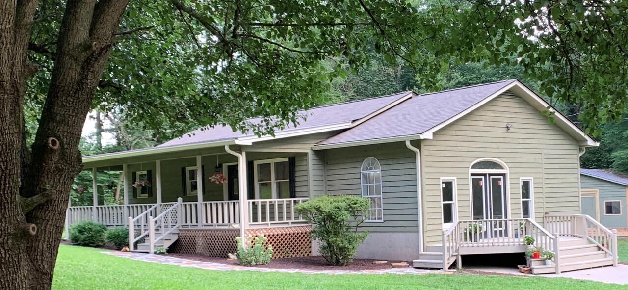 a view of house with a yard and a garden