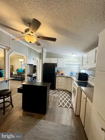 a living room with furniture a flat screen tv and a refrigerator