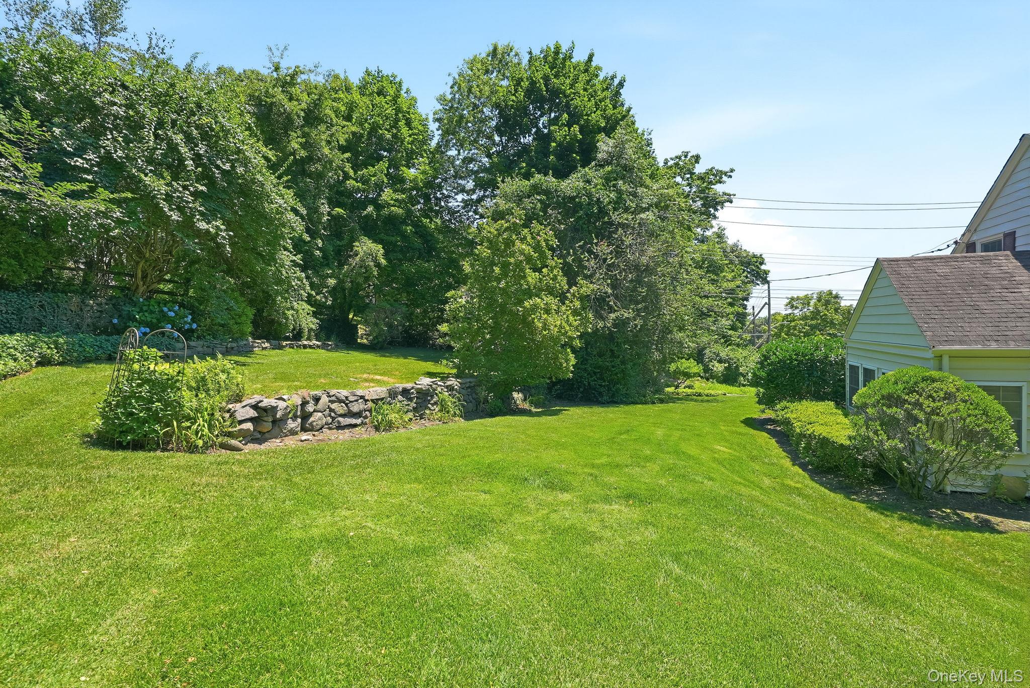1 Sheridan Road Scarsdale, NY 10583 - Photo 35 of 40 View of backyard showing stone wall and private, upper grassy area