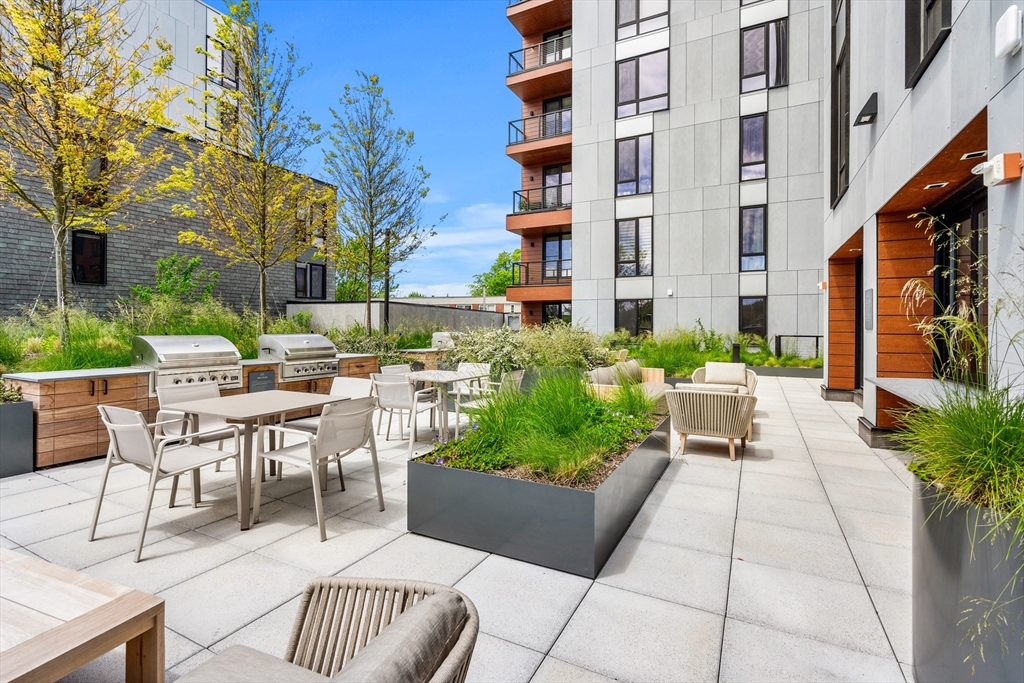 1515 Commonwealth Avenue, Unit 806 Boston, MA 02135 - Photo 18 of 21 a view of a patio with a table and chairs and potted plants