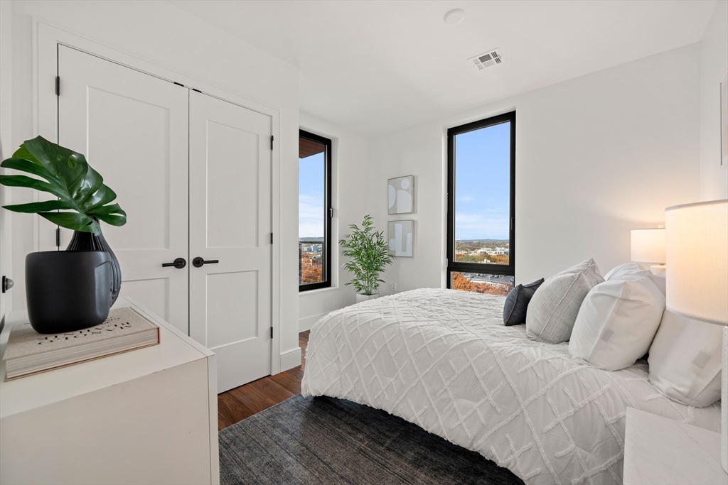 1515 Commonwealth Avenue, Unit 806 Boston, MA 02135 - Photo 8 of 21 a bedroom with a bed and a potted plant