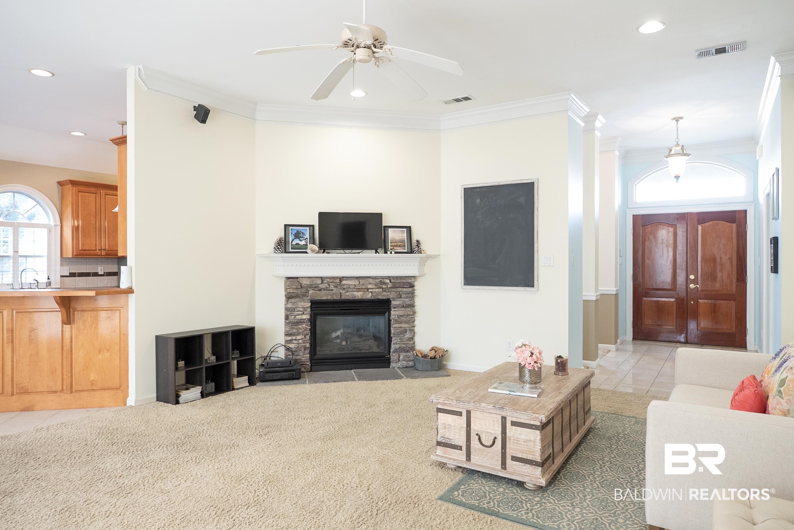 10023 Springfield Court Mobile, AL 36695 - Photo 14 of 50 Tiled living room with recessed lighting, a stone fireplace, a ceiling fan, carpet flooring, and ornamental molding