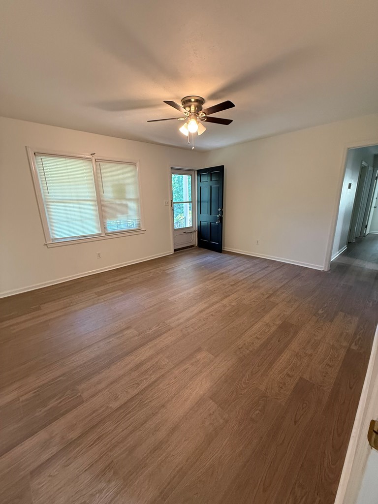 4355 Byron Street Columbus, GA 31907 - Photo 6 of 20 an empty room with wooden floor chandelier fan and windows