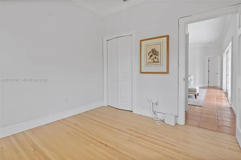 a view of a hallway with wooden floor and cabinet