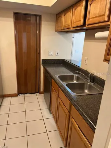a kitchen with a sink a refrigerator and cabinets