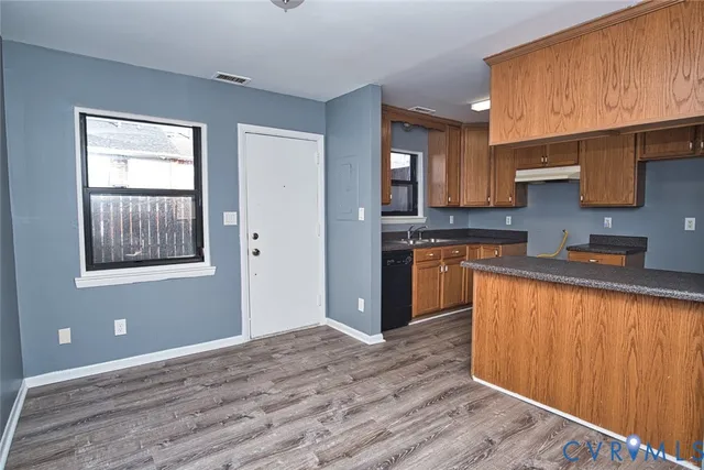 a kitchen with granite countertop wooden cabinets stainless steel appliances a sink and a window