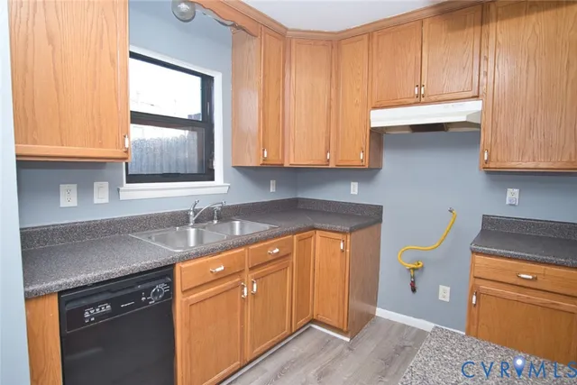 a kitchen with granite countertop wooden cabinets a oven and a counter top space