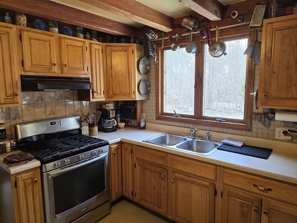 969 Brook Road Hardwick, MA 01037 - Photo 13 of 36 a kitchen with stainless steel appliances granite countertop a sink stove and cabinets