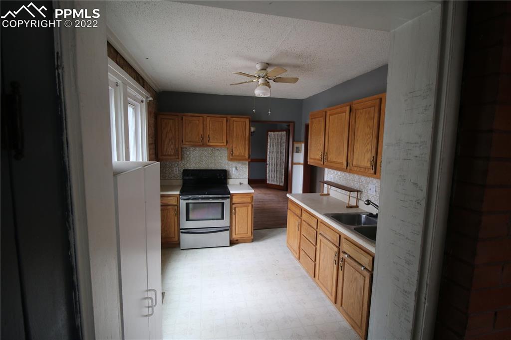 604 South Main Street Fowler, CO 81039 - Photo 10 of 50 a kitchen with a stove a sink and a refrigerator