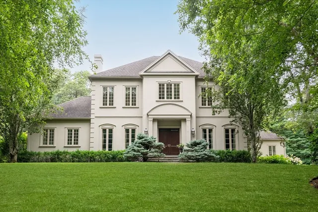 a front view of a white house with a yard