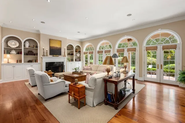 a living room with fireplace furniture and a large window