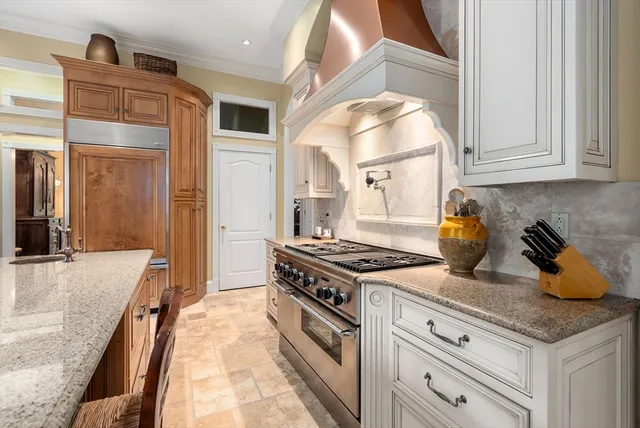 a kitchen with granite countertop a sink stove and cabinets