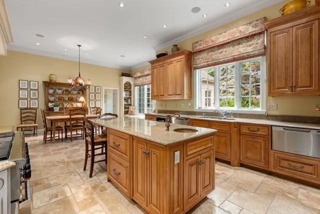 a kitchen with kitchen island granite countertop a sink stove and cabinets