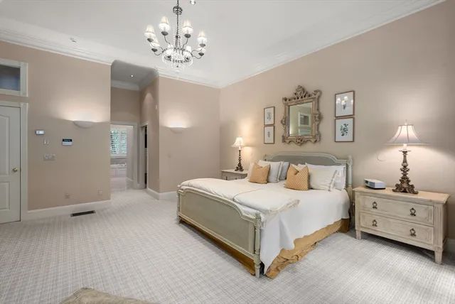 a spacious bedroom with a bed and a chandelier