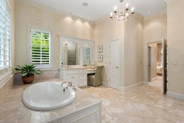 a spacious bathroom with a sink double vanity granite tub shower and a mirror