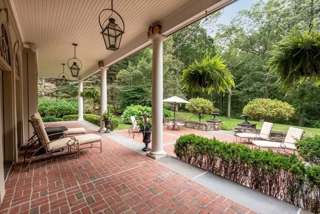 a view of a patio with chairs and potted plants