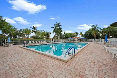 a view of a backyard with a table and chairs under palm trees