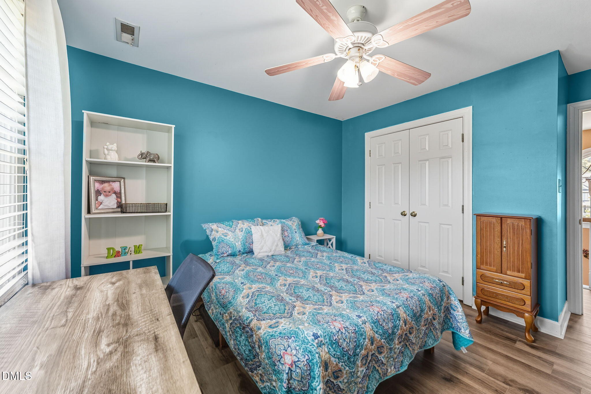 1617 Kendall Hill Road Willow Spring, NC 27592 - Photo 50 of 58 a bedroom with a large bed and a chandelier