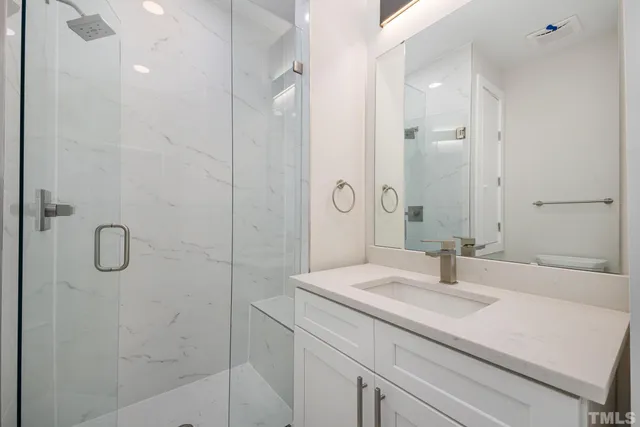 a bathroom with a sink shower and a mirror