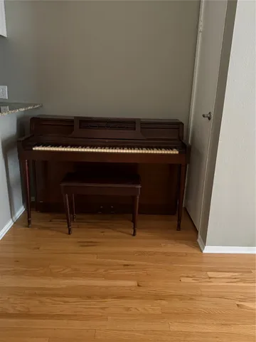 a living room with a piano and a table