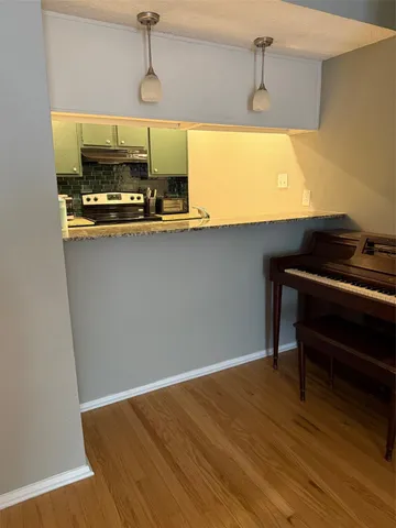 a kitchen with a sink and wooden floor