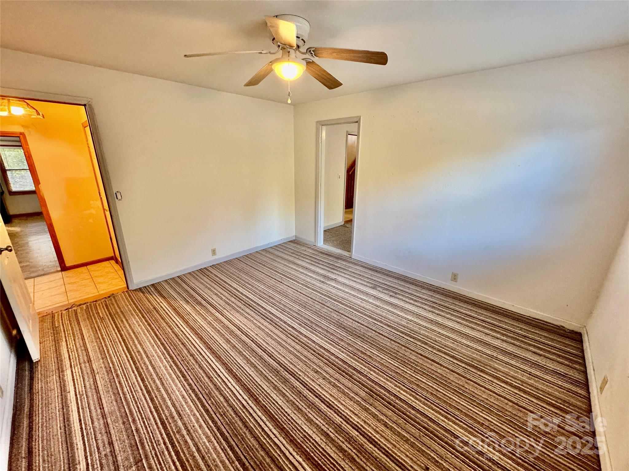 199 Bell Farm Road Statesville, NC 28625 - Photo 22 of 48 a view of a room with wooden floor and a ceiling fan