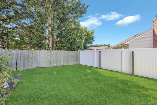a view of a backyard with potted plants and wooden fence