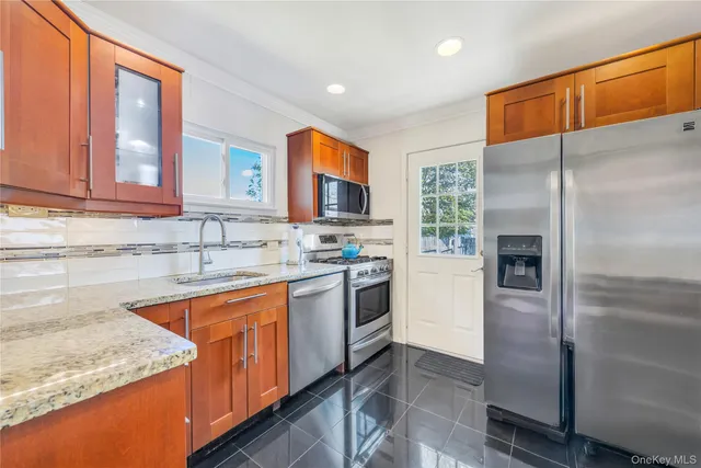 a kitchen with stainless steel appliances granite countertop a refrigerator and a sink