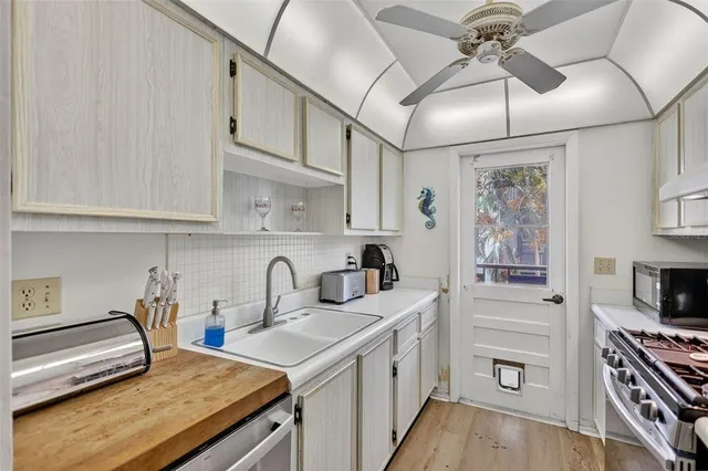 a kitchen with stainless steel appliances granite countertop a stove and a white cabinets