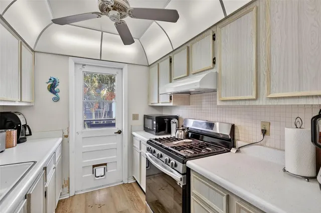 a kitchen with stainless steel appliances a sink stove and cabinets