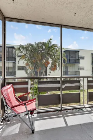 a view of a big building with a big yard and large trees