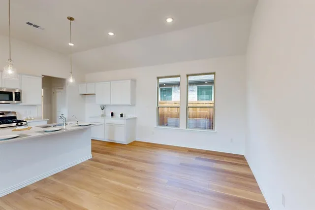 a view of a kitchen with wooden floor and a kitchen