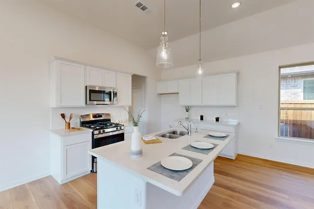 a kitchen with stainless steel appliances kitchen island granite countertop a sink and a stove