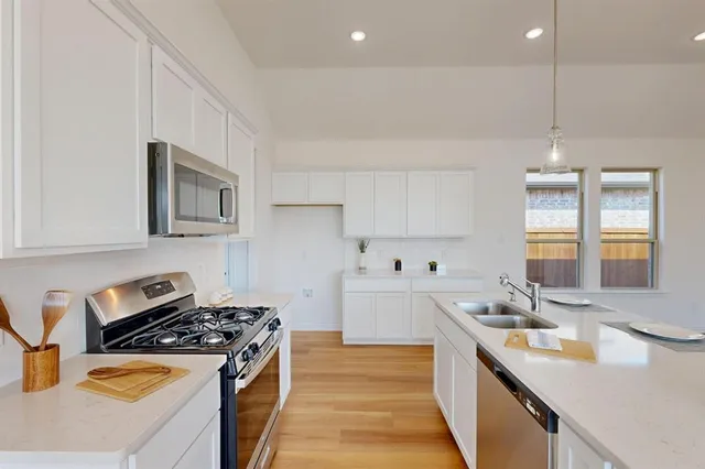 a kitchen with stainless steel appliances a sink stove and cabinets