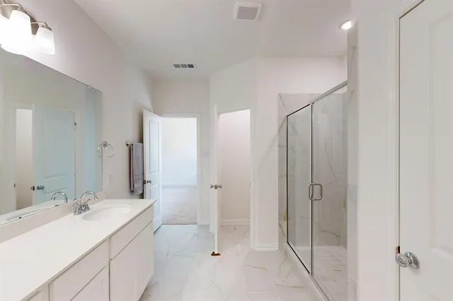 a bathroom with a double vanity sink mirror and shower