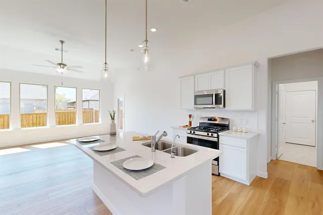 a kitchen with stainless steel appliances kitchen island granite countertop a sink and a stove