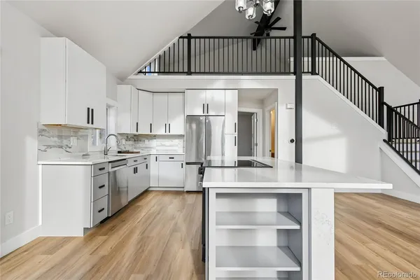 a kitchen with kitchen island granite countertop a sink cabinets and stainless steel appliances