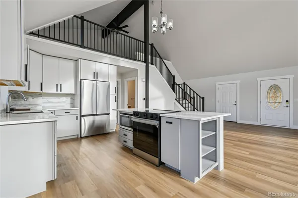 a kitchen with kitchen island a stove a sink and a refrigerator