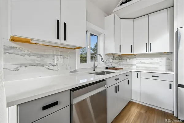 a kitchen with a sink cabinets and wooden floor